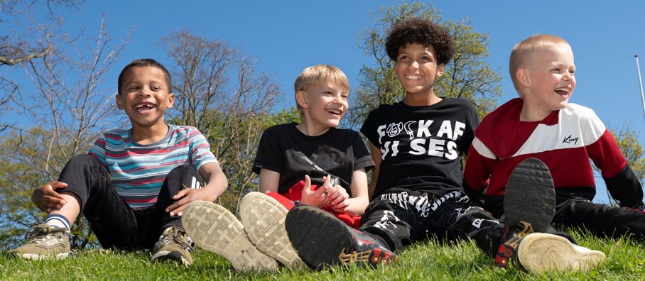 Drenge sidder på græs